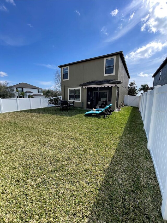 rear view of house featuring a yard