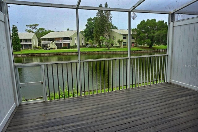 wooden deck with a yard, glass enclosure, and a water view