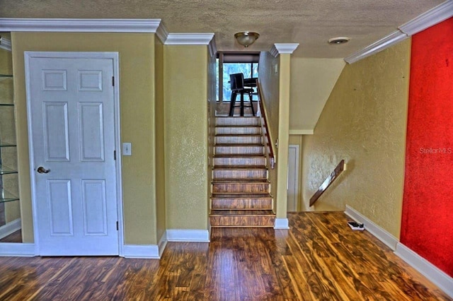 interior space with a textured ceiling, dark wood-type flooring, and crown molding