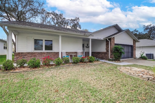 single story home featuring a porch, a front yard, central air condition unit, and a garage