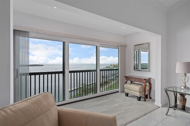 living area with a water view and light tile floors