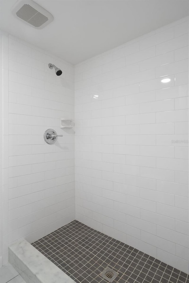 bathroom featuring a tile shower and tile floors