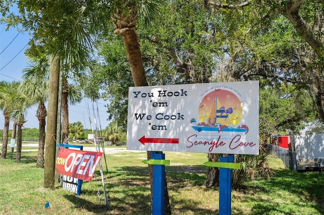 community / neighborhood sign featuring a lawn