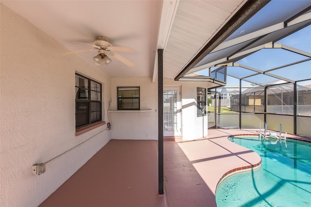 view of swimming pool featuring a patio area, ceiling fan, and glass enclosure