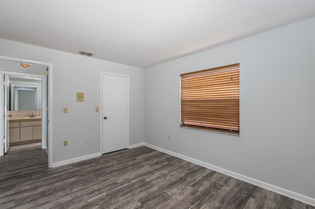 empty room featuring dark wood-type flooring and a textured ceiling