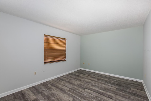 unfurnished room with a textured ceiling and dark wood-type flooring