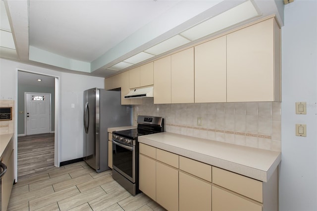 kitchen with backsplash, appliances with stainless steel finishes, and light wood-type flooring