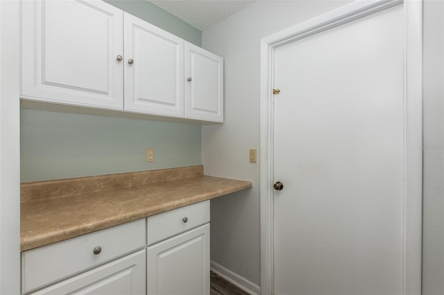 interior space featuring white cabinets and a textured ceiling