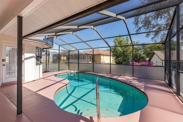 view of swimming pool featuring glass enclosure and a patio area