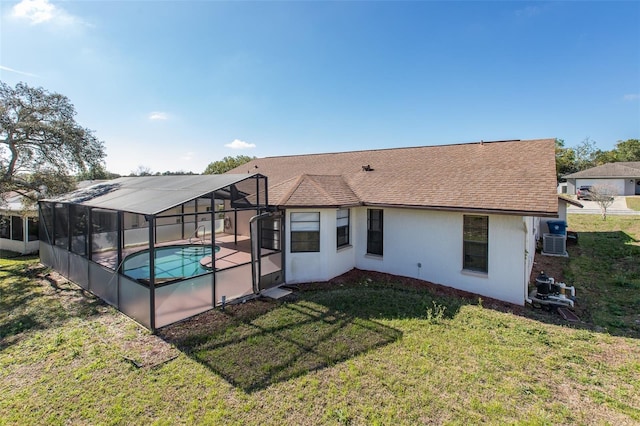 rear view of house featuring a lanai, a yard, and a fenced in pool