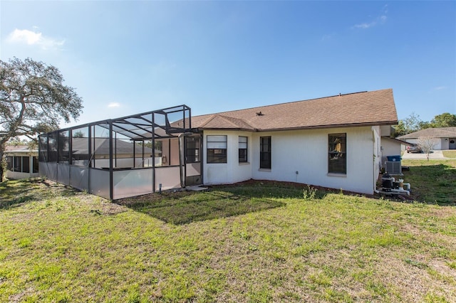 rear view of property with a yard, a swimming pool, and glass enclosure