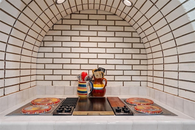 kitchen with tasteful backsplash, vaulted ceiling, and black electric cooktop