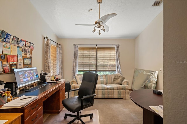 carpeted office with ceiling fan and a textured ceiling