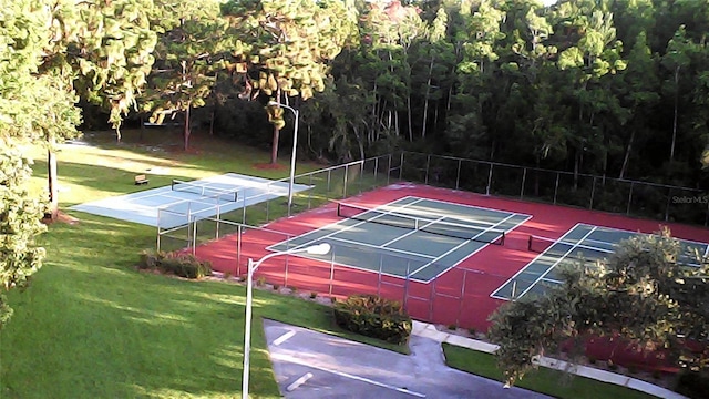 view of sport court featuring tennis court and a yard