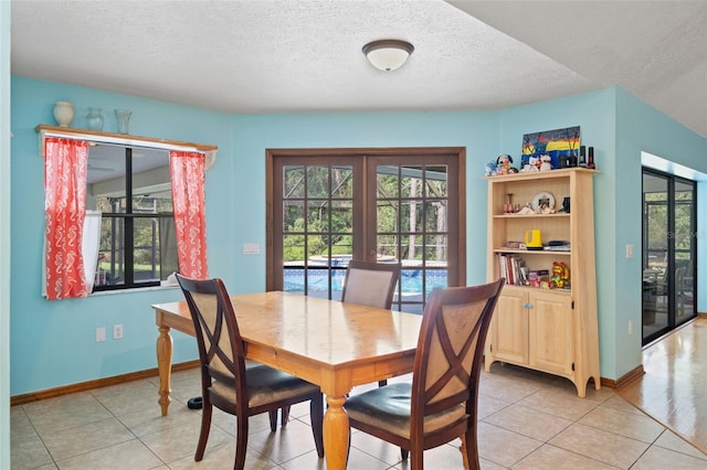 tiled dining room featuring french doors and a textured ceiling