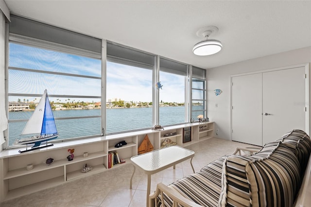 interior space featuring light tile patterned floors and a water view