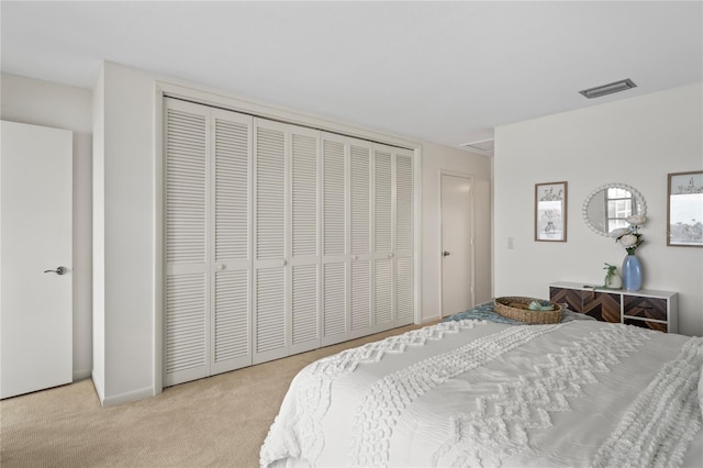 carpeted bedroom with a closet and visible vents