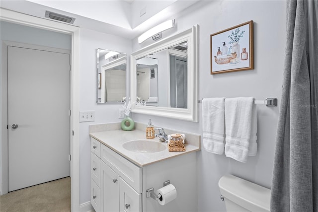 bathroom with visible vents, vanity, and toilet