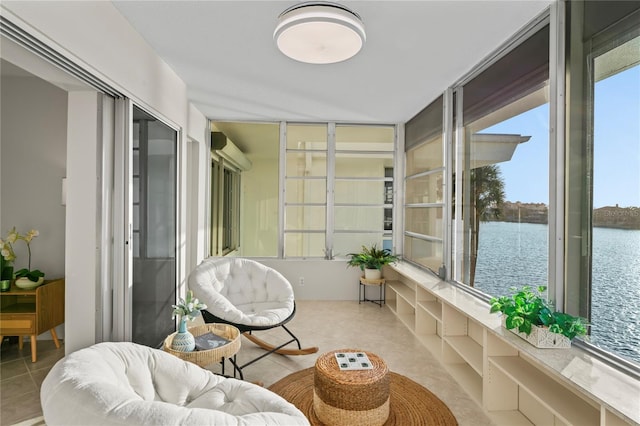 sunroom featuring a water view and an AC wall unit