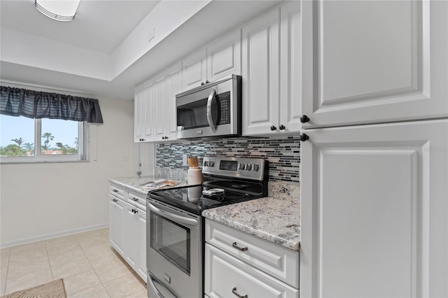 kitchen with light tile patterned floors, white cabinetry, appliances with stainless steel finishes, and decorative backsplash