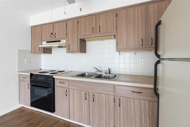 kitchen featuring black electric range oven, sink, dark hardwood / wood-style floors, decorative backsplash, and white fridge