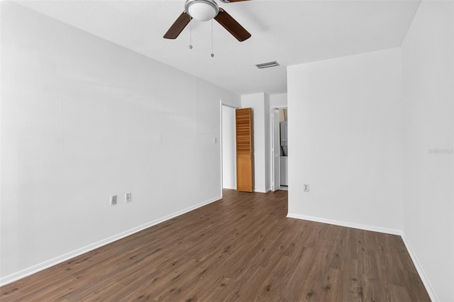 empty room with ceiling fan and dark wood-type flooring