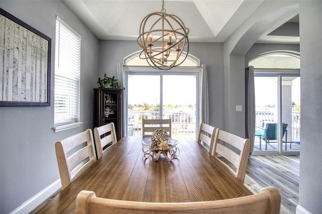 dining space with a chandelier, lofted ceiling, and hardwood / wood-style flooring