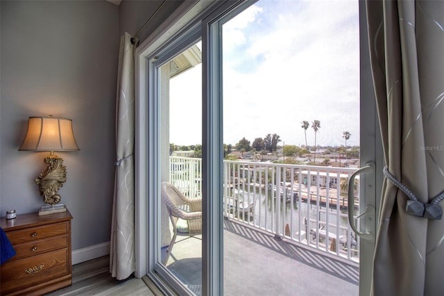 doorway to outside featuring hardwood / wood-style flooring and a water view