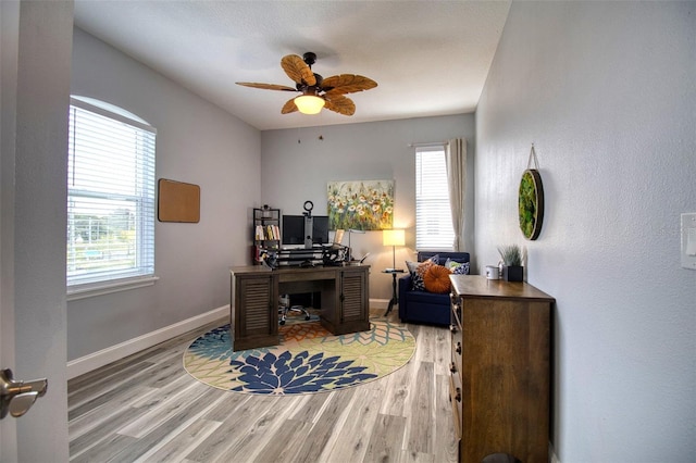 office space featuring light wood finished floors, ceiling fan, and baseboards