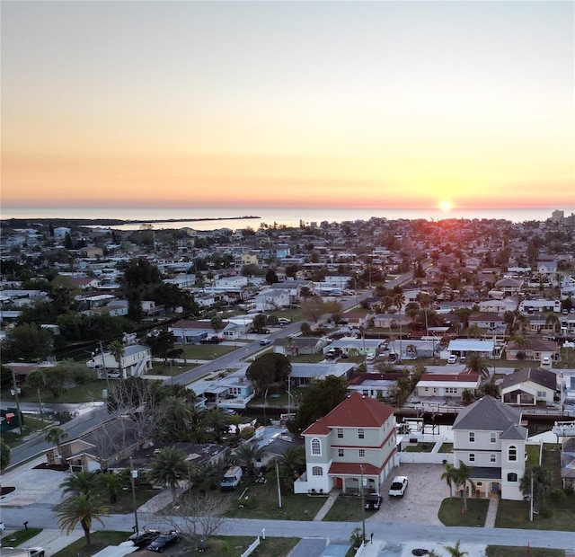 aerial view at dusk featuring a water view