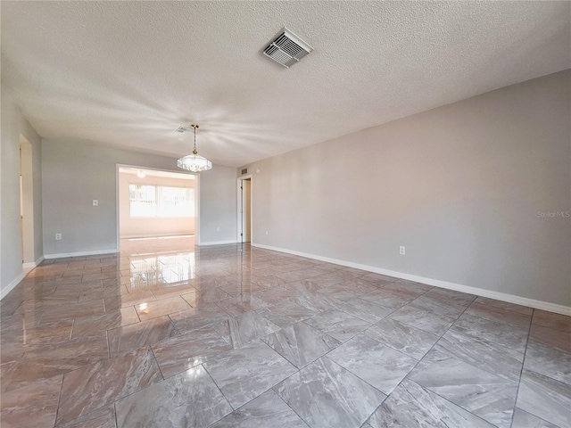 empty room with marble finish floor, visible vents, and baseboards