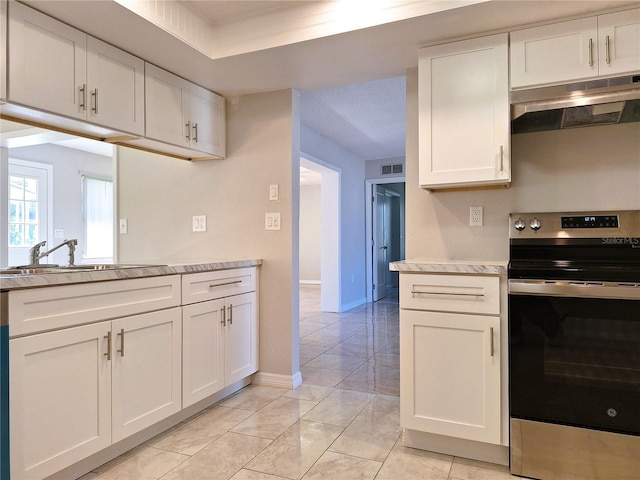 kitchen featuring light countertops, visible vents, stainless steel range with electric cooktop, a sink, and under cabinet range hood