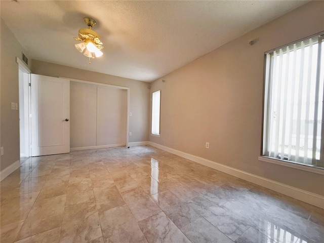 unfurnished bedroom with a closet, baseboards, and a textured ceiling