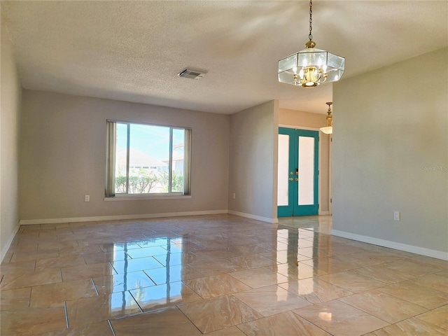 empty room featuring a textured ceiling, a notable chandelier, visible vents, baseboards, and marble finish floor