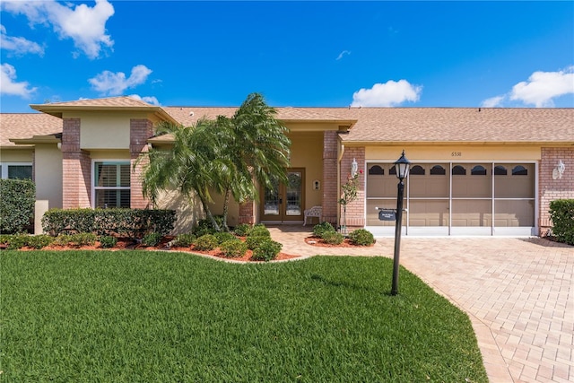 ranch-style home featuring a front lawn and a garage