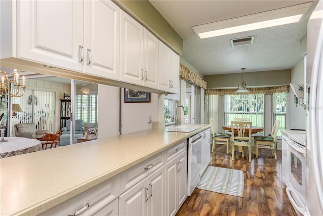 kitchen featuring dark hardwood / wood-style floors, hanging light fixtures, white cabinetry, and sink