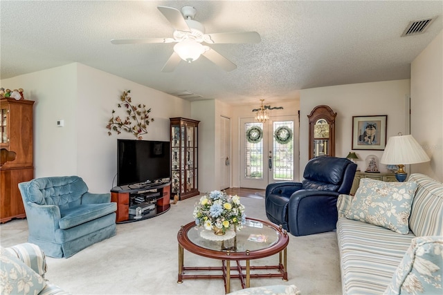 living room with french doors, a textured ceiling, ceiling fan, and light colored carpet