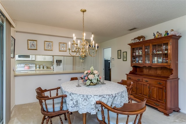 dining room featuring a notable chandelier, light carpet, and a textured ceiling