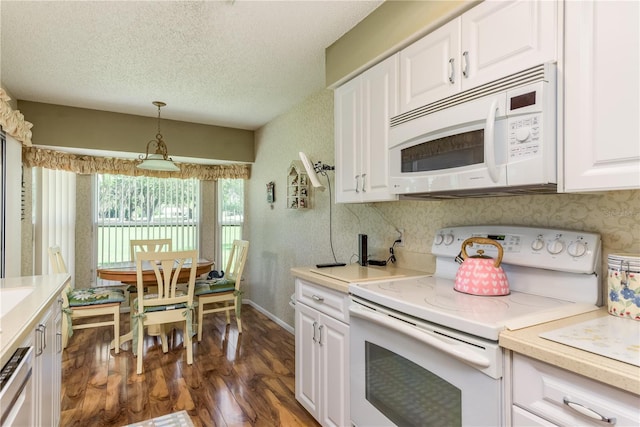 kitchen featuring pendant lighting, a textured ceiling, white appliances, white cabinetry, and dark hardwood / wood-style flooring