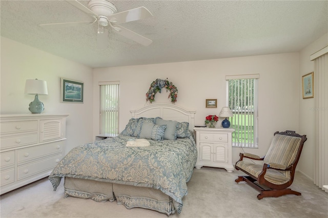 carpeted bedroom with a textured ceiling and ceiling fan