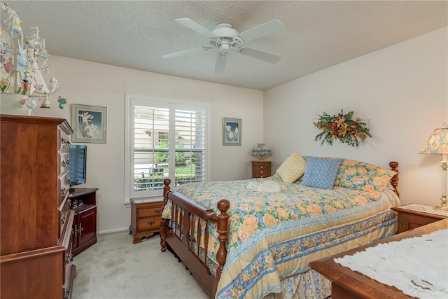 carpeted bedroom with ceiling fan and a textured ceiling