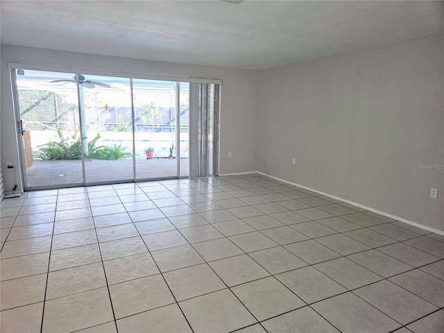 empty room with a healthy amount of sunlight, ceiling fan, and light tile patterned floors