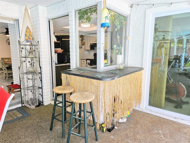 bar featuring dark carpet and ceiling fan