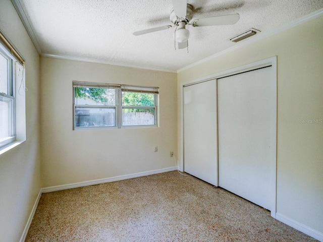 unfurnished bedroom with a closet, a textured ceiling, crown molding, and ceiling fan