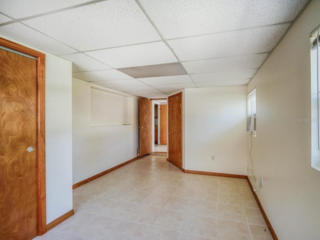 unfurnished room featuring a paneled ceiling and light tile floors