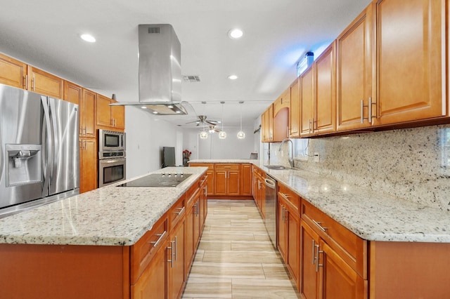 kitchen featuring backsplash, appliances with stainless steel finishes, island exhaust hood, light stone countertops, and ceiling fan