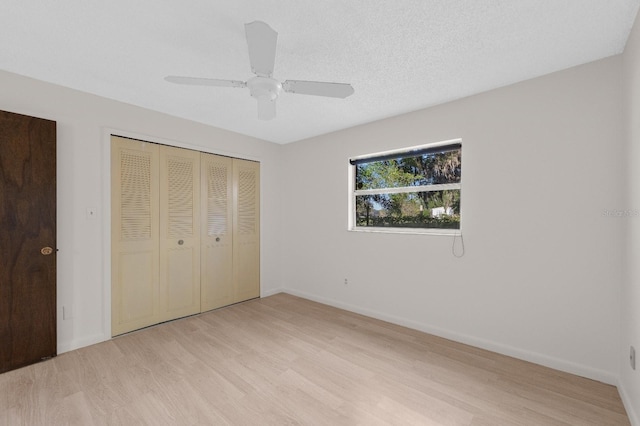 unfurnished bedroom featuring ceiling fan, a closet, and light hardwood / wood-style flooring