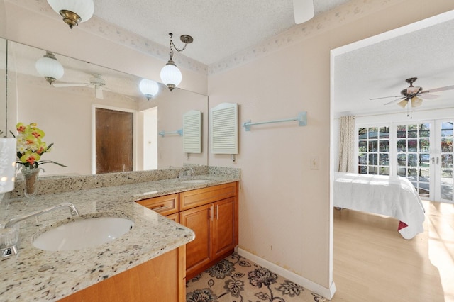 bathroom with hardwood / wood-style flooring, dual vanity, ceiling fan, and a textured ceiling