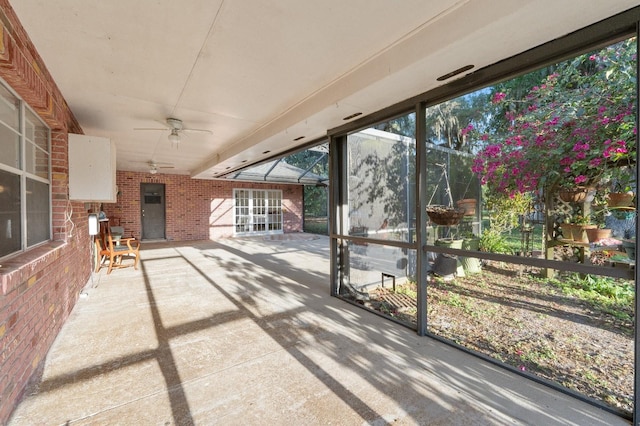 unfurnished sunroom featuring ceiling fan