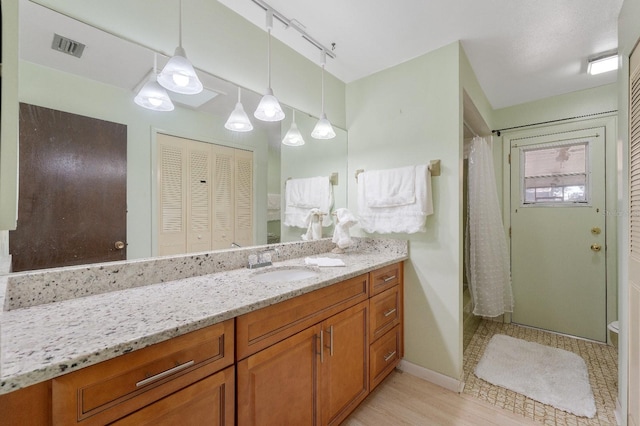 bathroom featuring toilet, track lighting, and vanity